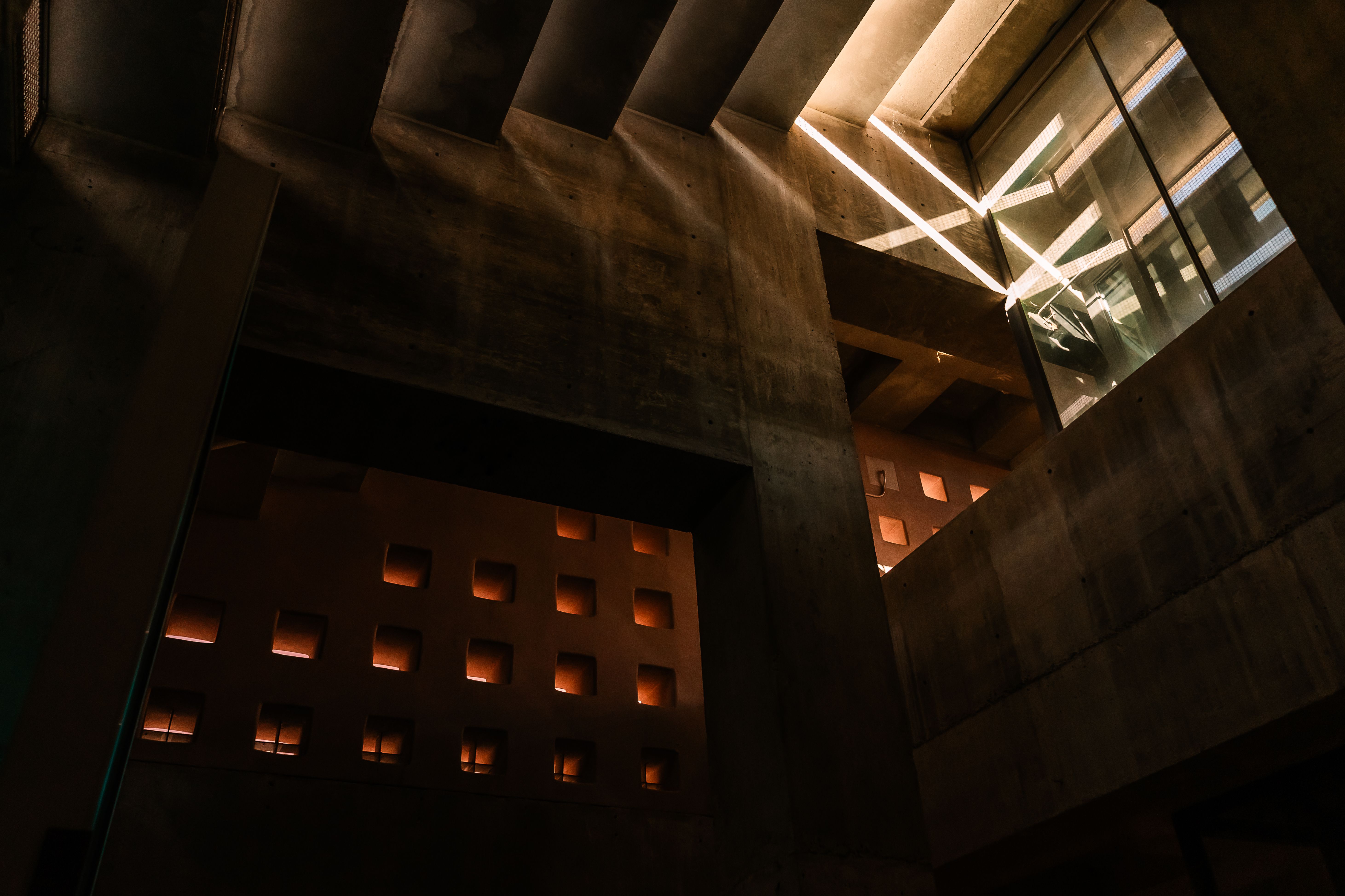 Raking daylight across a raw concrete interior